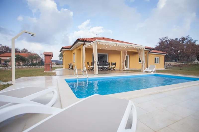 Pool mit Terrasse vor einem Einfamilienhaus