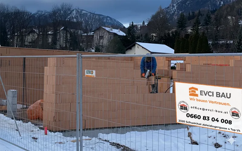 Ziegelrohbau im Winter mit Evci-Bau-Bautafel