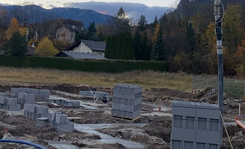 Baustelle mit Mantelsteinen und Ziegelpaletten zu Baubeginn