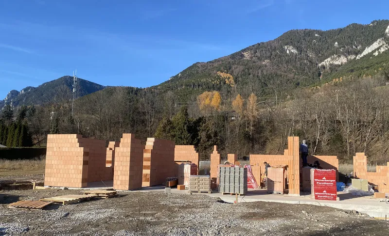 Ziegelmauerwerk im Erdgeschoß mit Bergkulisse